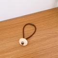 Brown high elasticity hair tie featuring a white round button with Love script - Off-White