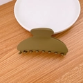 Minimalist matte olive green hair claw clip displayed on a white plate on a wooden desk - Army Green