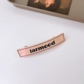 French vintage peach pink letter hair clip with black larmood print on white background - Apricot