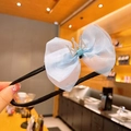 Chouchou avec nœud en organza bleu et couronne de strass tenu dans la main - 8# Couronne Nœud