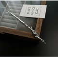 Horquilla de plata con forma de serpiente y esmalte verde sobre joyero oscuro - Estilo de Serpiente Plateada Con Toques Verdes