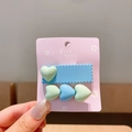Set of two colorful resin heart hair clips in blue and green on a pink card - Heart Blue