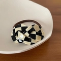 Détail d'un chouchou damier fait main avec lettrage France poli sur fond de bois sombre - Style Damiers Noir Et Blanc