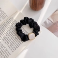 Close-up of black satin scrunchie with white marble square charm and golden beads detailing - White