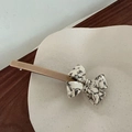 Eleganter beiger Haarclip mit schwarz-weißer Marmortextur auf einer weißen Platte - Aprikose