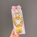 Detalle del conjunto de joyas para niños con lazos amarillos y perlas en el empaque - Amarillo