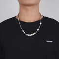 Detalle de collar con perlas graduadas y cuentas plateadas sobre un cuello redondo negro - 60CM / Plata