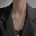 Minimalist silver cross pendant necklace shown on a model neck with a black blazer - Polished Cross Necklace