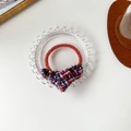 Elegant red tweed bow hair tie with fringed edges on a glass tray minimalist style - Red