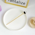 Épingle à cheveux dorée minimaliste avec perle noire et claire sur plateau blanc - Ciel Étoilé Noir