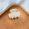 Eleganter perlmutt-cremeweißer Acetathair-Claw-Clip auf einem Holzdisplay-Tablett - Perlmuttrosa