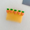 Yellow kids hair comb with five cartoon carrots on textured cream fabric - Carrot