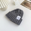 Dark grey chunky knit beanie for women with white label tag and warm cable stitch pattern - Gray
