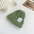 Thick dark green cable knit beanie with a stylish white ribbed cuff and brand label - Green