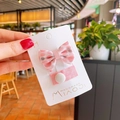 Dettaglio del fermaglio per capelli con fiocco rosa e spilla in tessuto su carta - Rosa