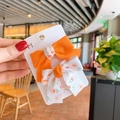 Set of two sweet floral and bright orange bow hair clips on a white display card - Orange Marble