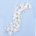 Detailed macro of handmade bridal hairpiece with matte resin flowers and pearls - Gold