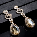 Elegant champagne crystal drop earrings with sparkling rhinestone swirls on black display - Champagne