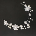 Tocado de novia hecho a mano con flores blancas mate y perlas sobre fondo negro - Pétalo Redondo Plateado