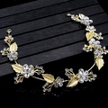 Close-up of handmade gold leaf hairband with crystal flowers on a black textured stand - Style 7 Handmade Floral (TS060)