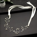 Silver bridal headband featuring handmade pearls and rhinestones on a black display tray - White