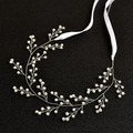 Macro view of handmade bridal hair vine with white pearls and silver wire on black base - Silver