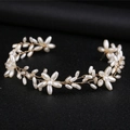 Elegante vite per capelli da sposa dorata con fiori di perle bianche su fondo scuro - Oro