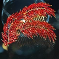 Elegant gold-tone feather hair comb encrusted with vibrant red rhinestones on a sleek black base - Red