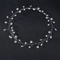 Detailed close-up of handmade bridal headband with white pearls and crystals on black background - White