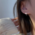 Élégantes boucles d'oreilles créoles fleurs en argent S925 portées par un mannequin - Or blanc