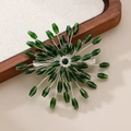 Detailed macro view of an emerald green crystal starburst hair clip with silver setting - Dark Green