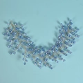 Dettaglio di un accessorio sposa con cristalli azzurri e intreccio di fili dorati - Blu