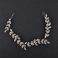 Detailed macro view of sparkling rhinestone leaf bridal headband on a dark backdrop - Gold Style 1