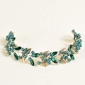 Detalle de diadema hecha a mano con hojas doradas, cristales verde esmeralda y perlas - Oro-Perla Verde