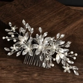 Silberner Braut-Haarkamm mit Kristallblumen und weißen Perlen auf dunklem Holzgrund - Silber