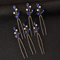 Detailed view of U-shaped hair pins with blue crystals and pearls in gold branch design - Blue