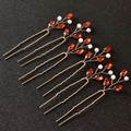 Detailed macro view of 5-piece gold U-shaped hair pins with red crystals and pearls - Red