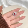 Elegante anello con rubino sangue di piccione e halo di diamanti indossato da modella - Aperto Regolabile / Rosso (Rame Placcato Platino)