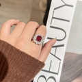 Vintage style women's ring with ruby main stone and surrounding diamond accents - Ring