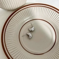 Boucles d'oreilles en argent en forme de haricot C sur une assiette en céramique - Argenté