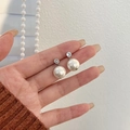 Elegante zilveren pareloorknopjes met fonkelende zirkoon tussen vingertoppen - Verzilverde Witte Schelpparel (925 Zilver Stift)