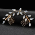 Close-up of golden marquise opal gem hair combs set with leaf-shaped floral design - Opal