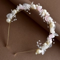 Detailed macro view of handmade bridal headband with white petals and pearls - Pink