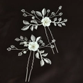 Dettaglio di due forcine per capelli argentate con fiori bianchi e perle di cristallo - Argento
