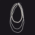 Detail einer dreilagigen weißen Perlenkette mit eleganten Schichten und Metallverschluss - Stil Drei Lang