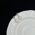Boucles d'oreilles nœud argenté avec pendentifs en perles blanches sur fond noir et blanc - Boucles d'Oreilles en Perles de Coquillage Nouées (Cuivre Plaqué Platine Tige Argent 925)