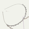 Cerchietto ondulato in lega d'argento con strass scintillanti su piedistallo bianco - Argento