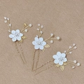 Gros plan d'épingles à cheveux fleurs blanches avec perles et cristaux sur tiges dorées en U - Or blanc