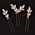 Dettaglio di tre forcine per capelli a foglia dorata con perle bianche e cristalli - Oro