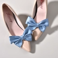 Close-up of elegant light blue satin multi-layered bow decoration on a pointed flat shoe - Blue